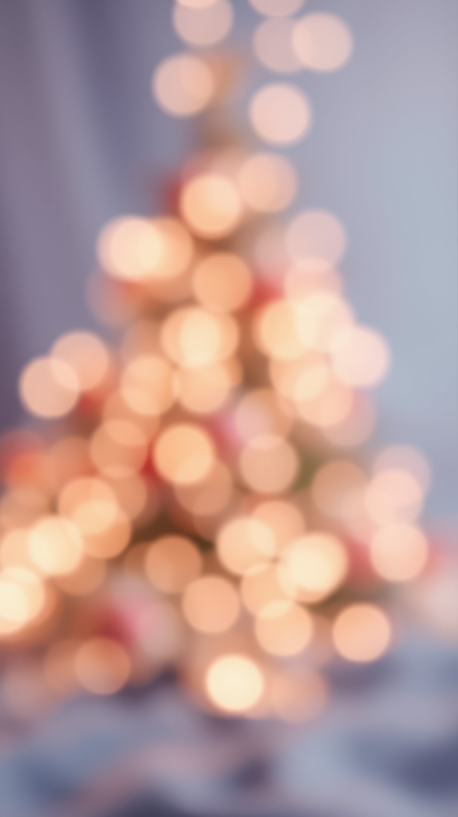 Blurred lights create a warm atmosphere of a decorated Christmas tree in a cozy indoor setting during the winter holidays